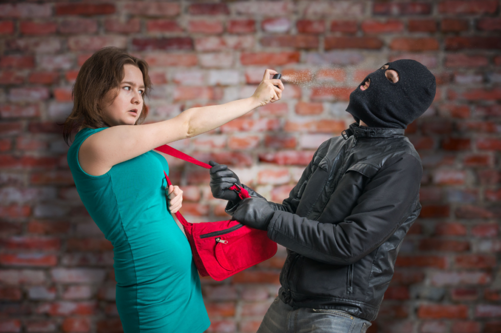 woman pepper spraying burglar