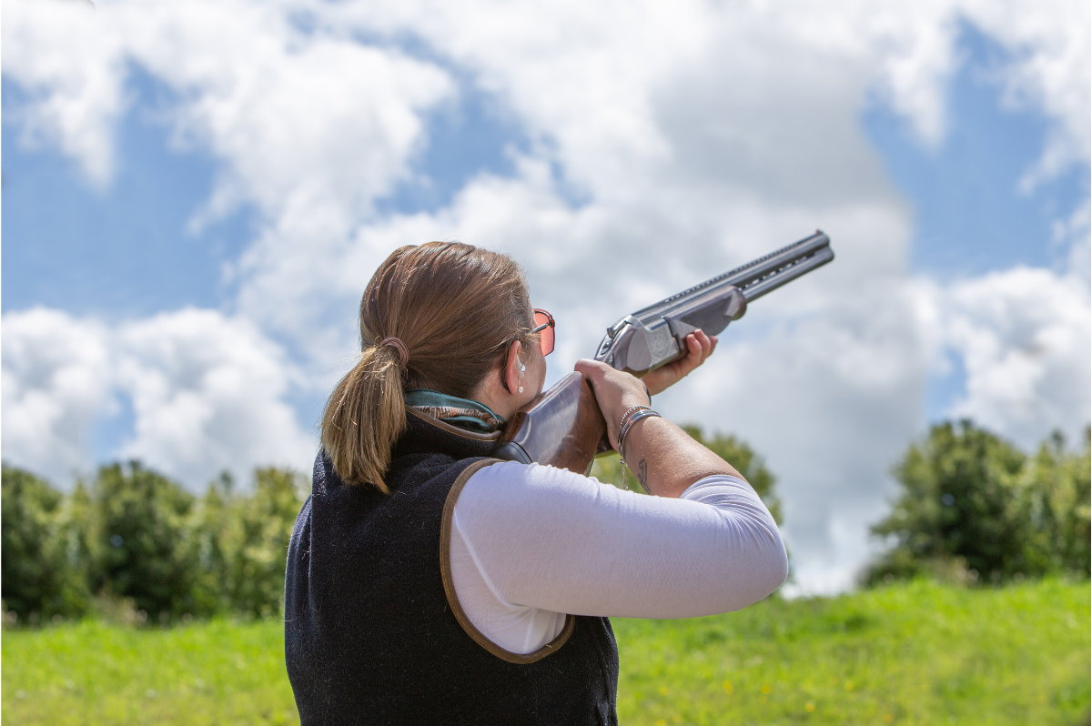 Women shooting shotgun outdoors